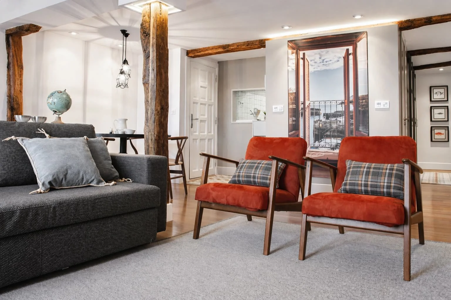 Zona de estar con sillones tapizados en tonos cálidos en salón reformado de estilo rústico costero