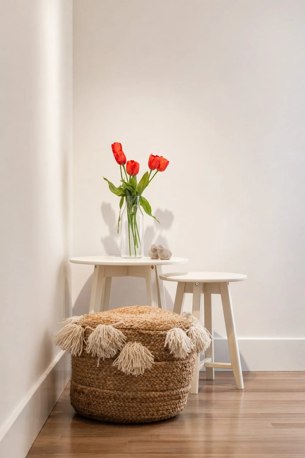 Mesa auxiliar con flores y puf de fibras naturales en decoración de estilo costero