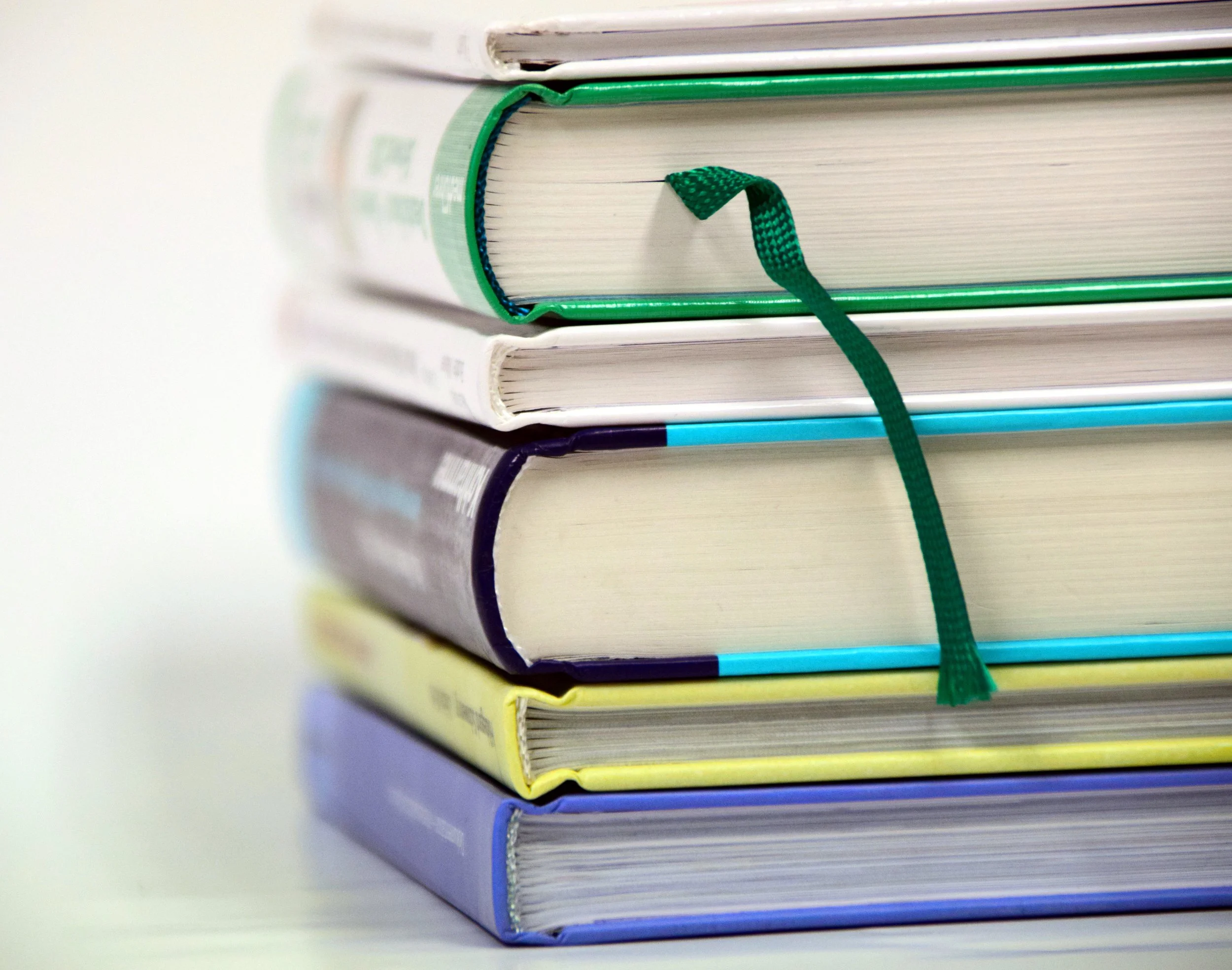 A stack of textbooks, the titles and topics of which are not visible