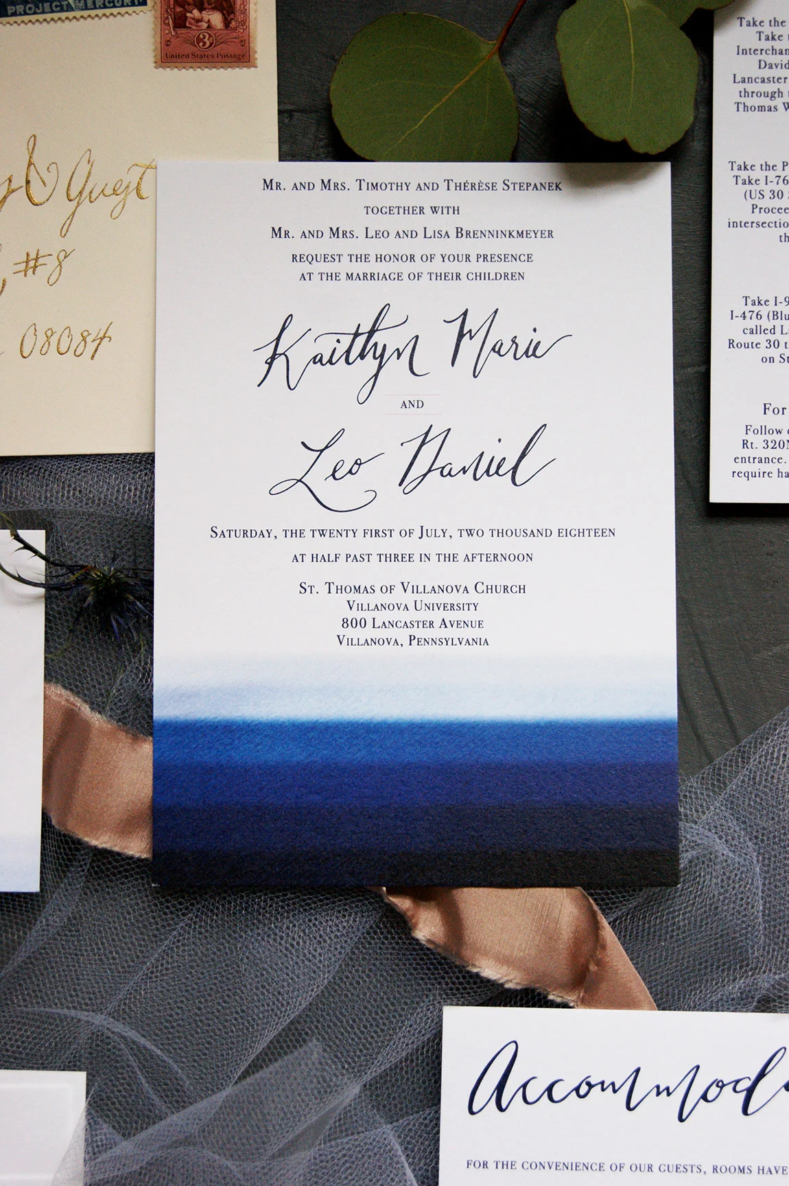 Navy watercolor wedding invitation with custom calligraphy and blush accents.