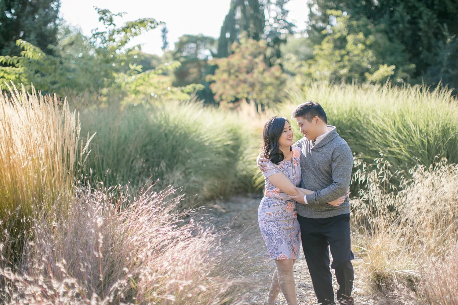 couple-hand-in-hand-during-engagement-session-laughing-as-they-walk-in-van-dusen-garden-vancouver-macy-yap-photography.jpg