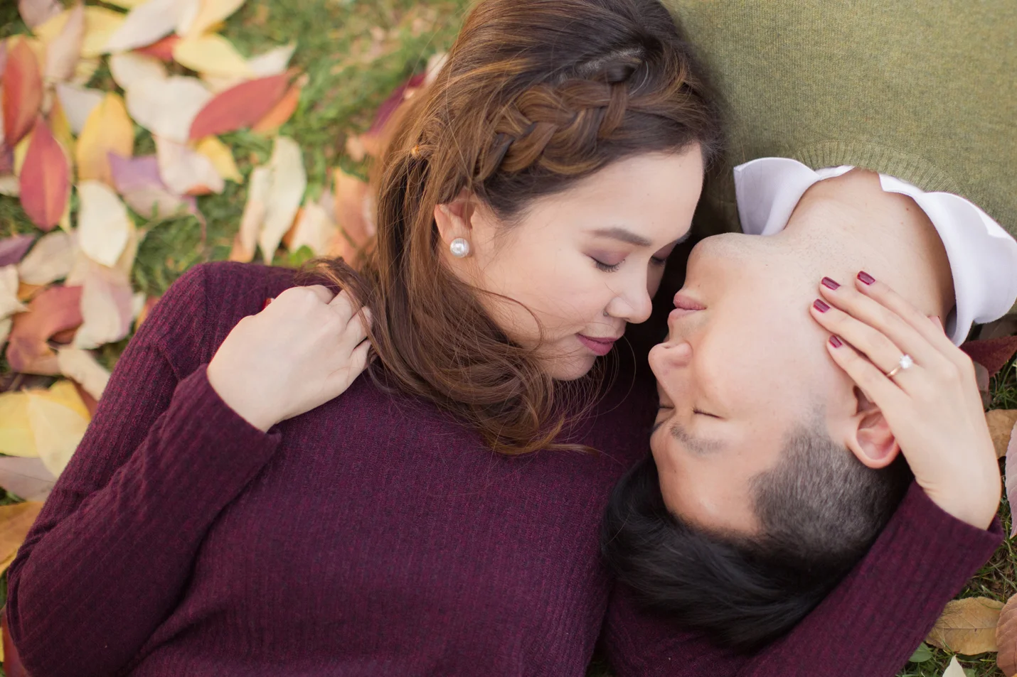 couple-lying-on-grass-with-fall-leaves-around-them-love-intimate session during autumn season in a vancouver park in burnaby-macy-yap-photography.jpg