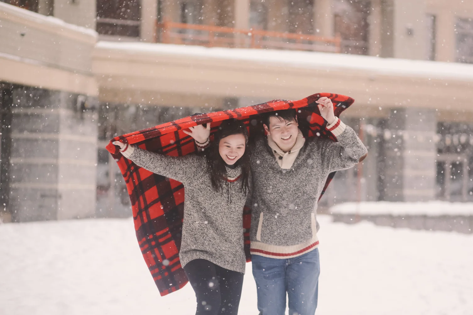 couple-running-in-the-snow-with-a-red-blanket-in-four-seasons-whistler-macy-yap-photography.jpg