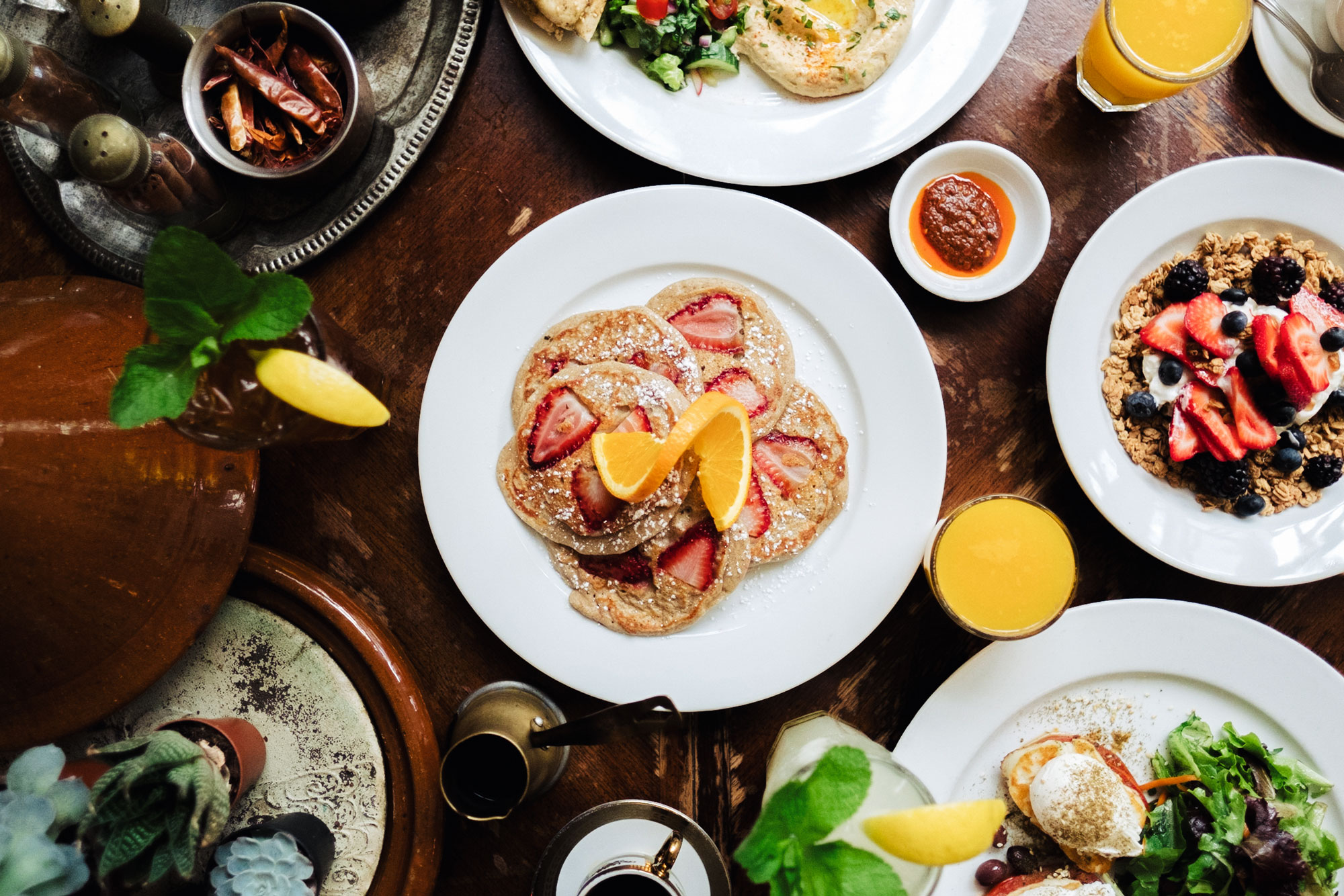 Breakfast spread, pancakes, granola, halloumi eggs, harissa, orange juice