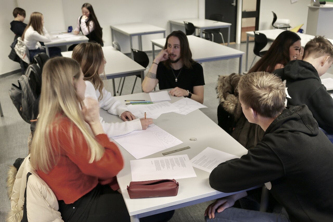 Norsklærer Mats (i midten av bildet) veileder elevene i tegneserietegning.