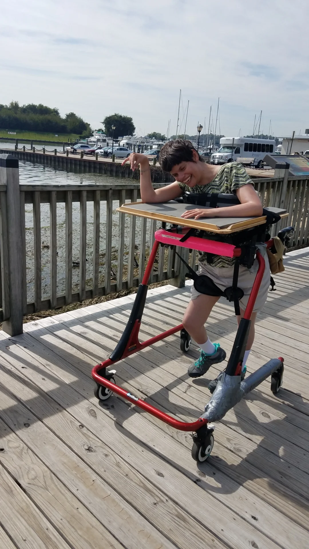 Being out at the lake is another popular community outing. Heather is walking on the pier in her Pacer. Going over uneven planks of wood is a challenge but Heather is determined to reach the end of the pier. Who would not enjoy looking out over the lake? Although the ladies may need assistance to walk to the bench they are able to sit independently on a typical park bench and “hang out” while enjoying a gentle breeze on a beautiful day.