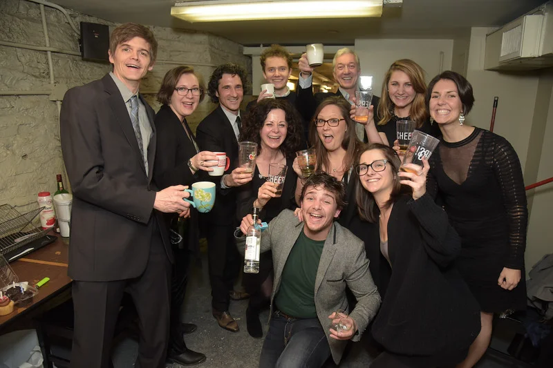 The whole crew raising a glass backstage to a successful opening