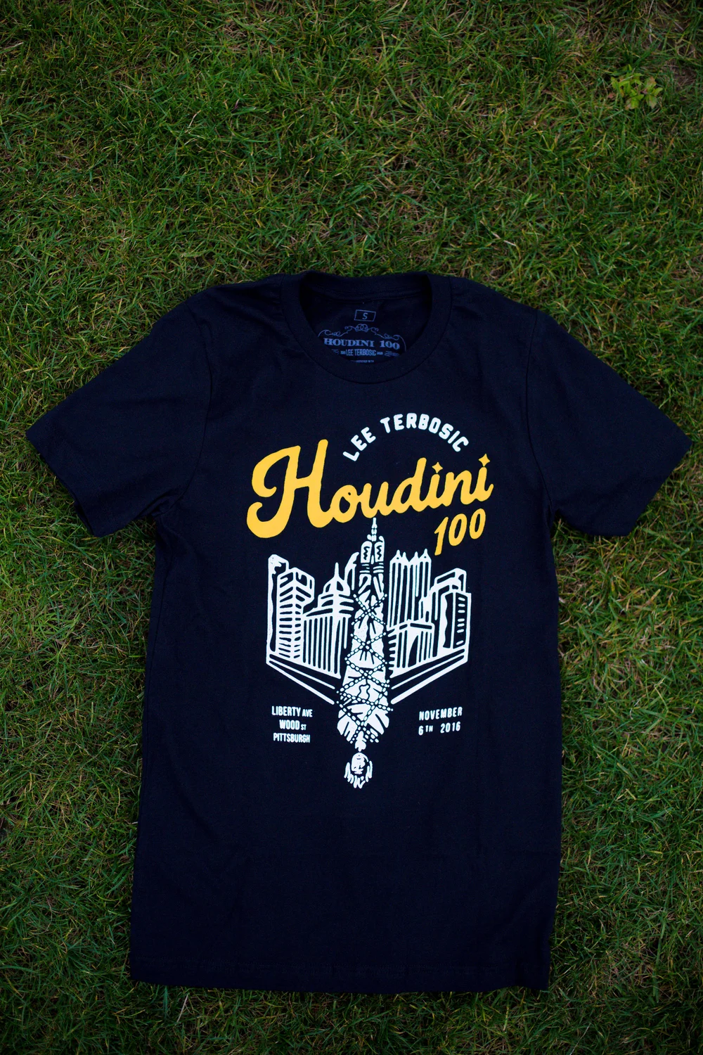Original 2016 Houdini 100 dark T-shirt with gold Pittsburgh skyline and upside-down escape design
