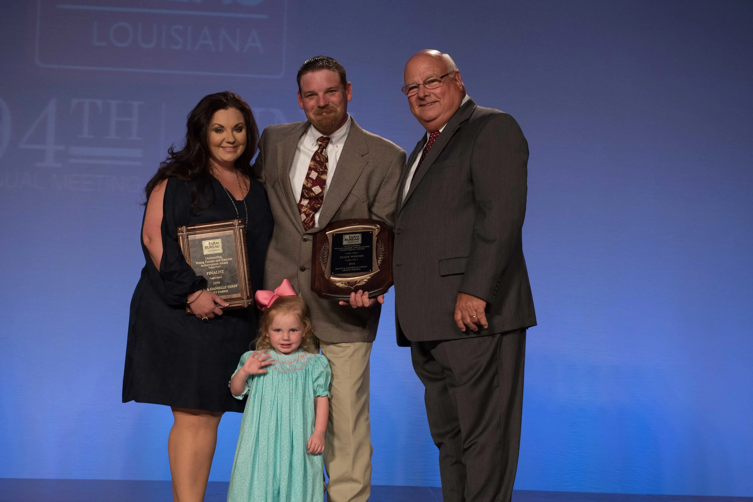 Ryan and Danielle Yerby of Grant Parish accept the 2016 Young Farmer and Rancher Achievement Award Thursday, June 23. Pictured, left to right: Danielle Yerby, Ryan Yerby, Reagan Yerby (front) and Louisiana Farm Bureau President Ronnie Anderson.