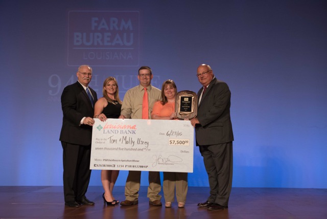 Tom and Molly Ursey of DeSoto Parish received a check from the Louisiana Land Bank as part of their prize package at the 94th Annual Convention of the Louisiana Farm Bureau. Pictured left to right: Stephen Austin, CEO, Louisiana Land Bank; Amelia Kent, Young Farmer and Rancher Chair; Tom Usrey, Molly Usrey, Ronnie Anderson, president, Louisiana Farm Bureau.