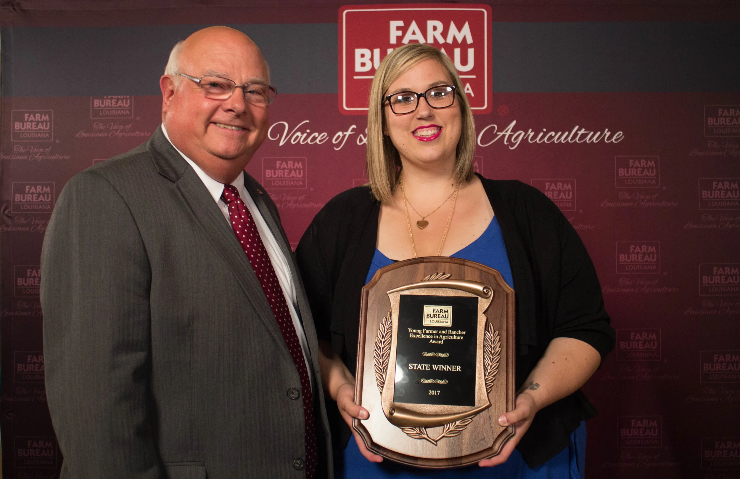 Louisiana Farm Bureau President Ronnie Anderson presents the 2017 Excellence in Agriculture Award plaque to Katie Sistrunk of Iberville parish.