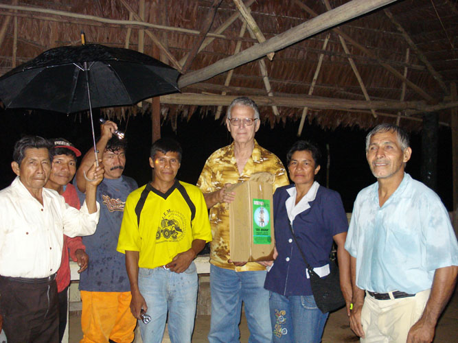 Dean Logan (LNDI) presenting emergency lighting equipment to Km 65 community.