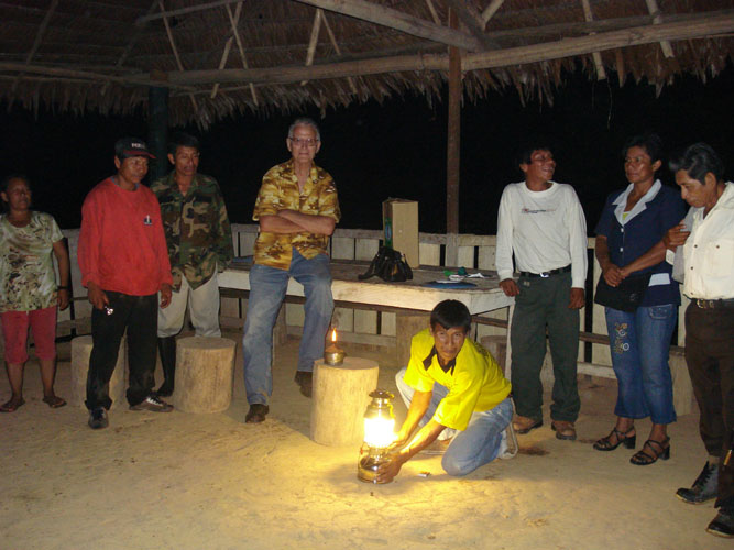 Community villagers gather around kerosene lamp presented by LNDI.