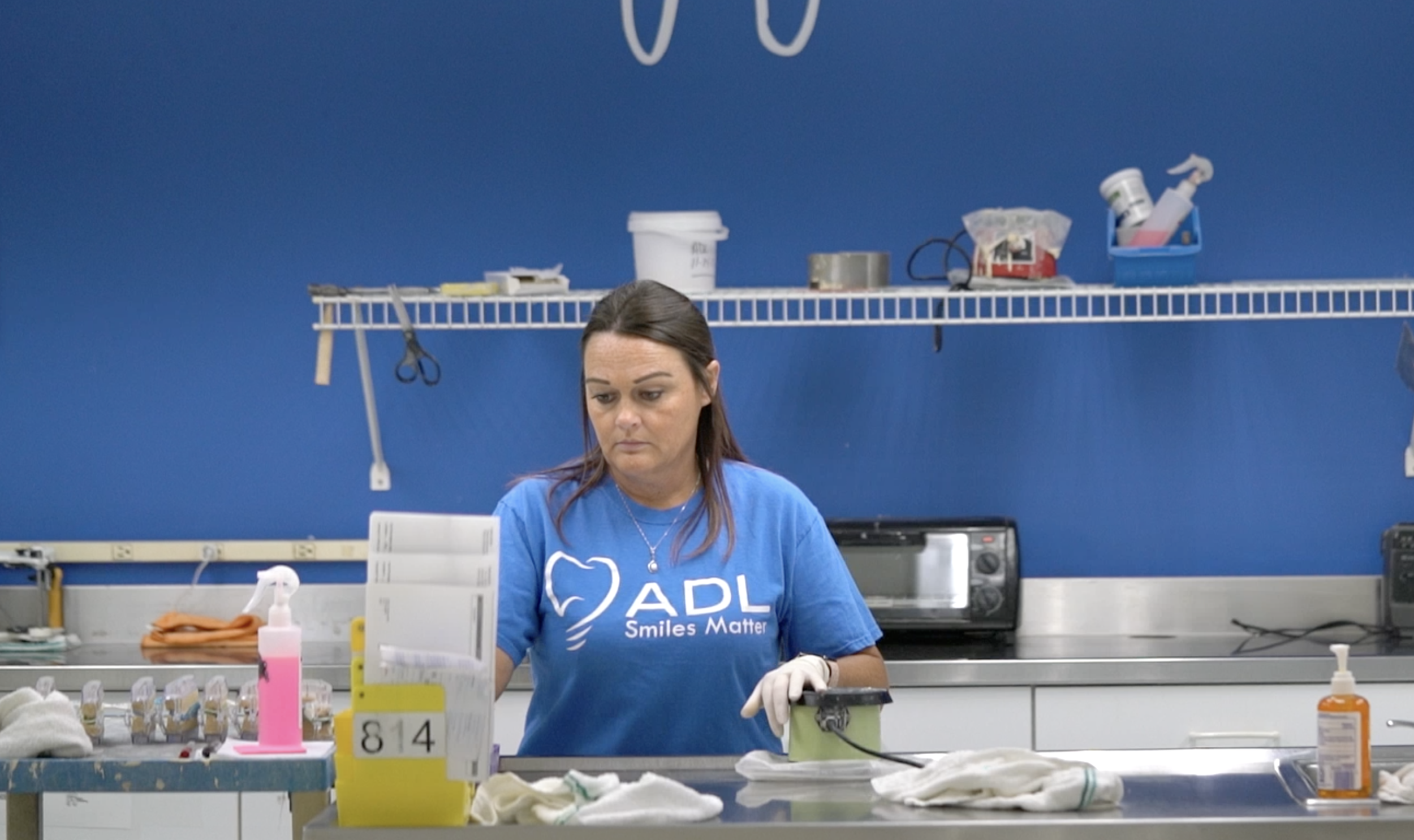 Employee packaging an order at the MicroDental ADL laboratory.