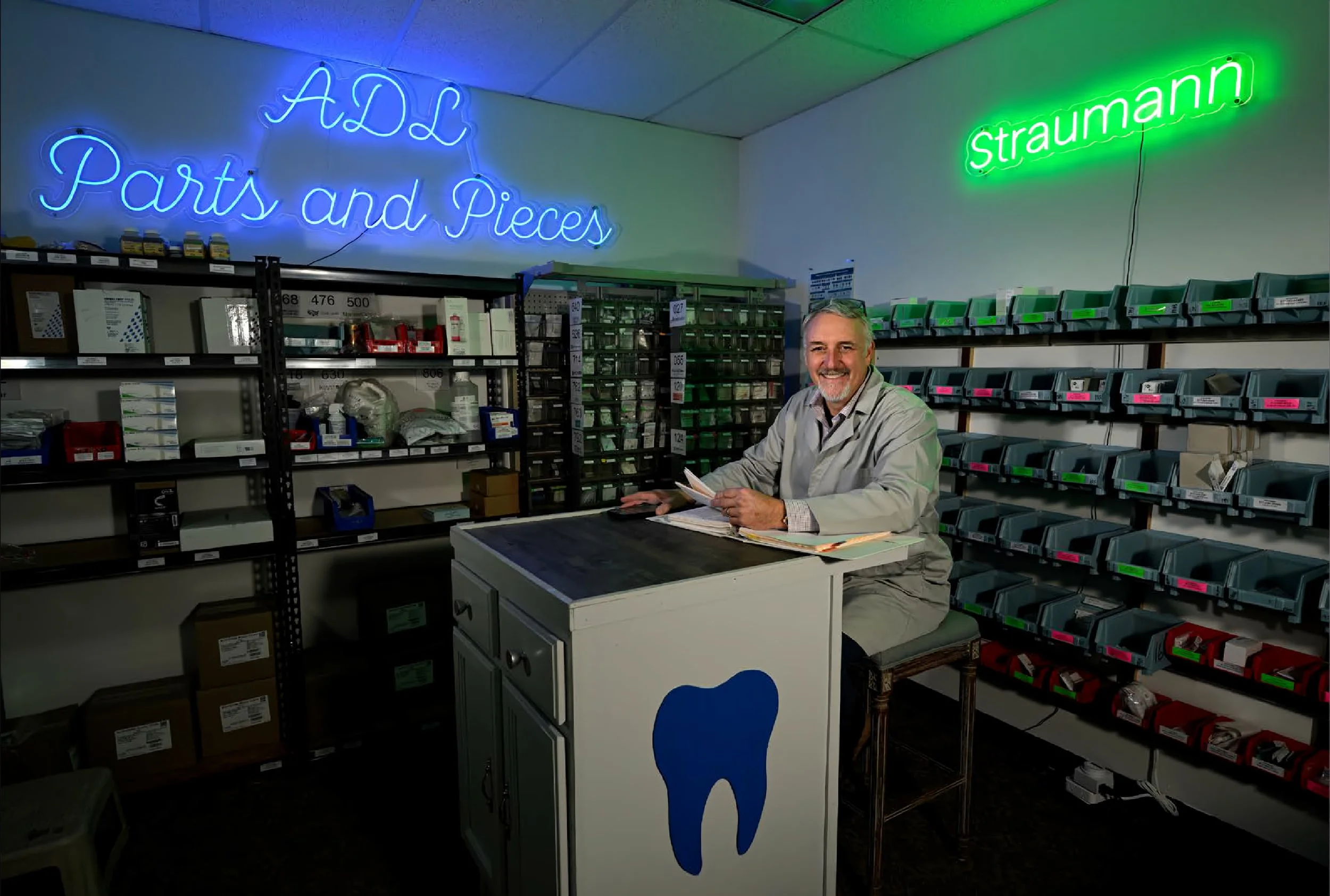 Chris Morris, MicroDental CEO, sitting in ADL's parts and pieces room at their lab.