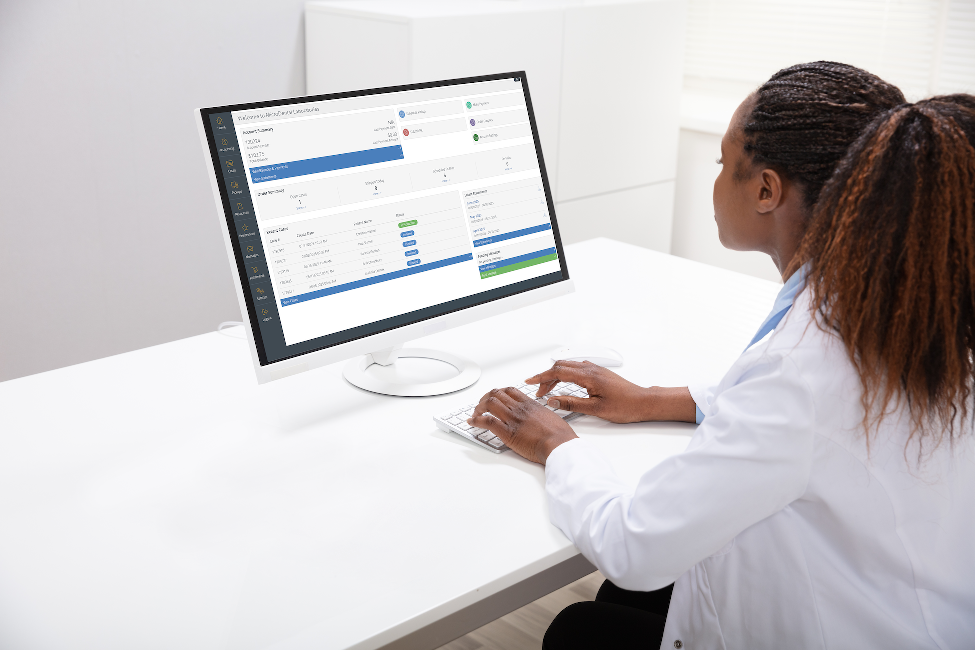 Someone sitting at a desk looking at the MicroDental case submission and tracking portal on a computer.