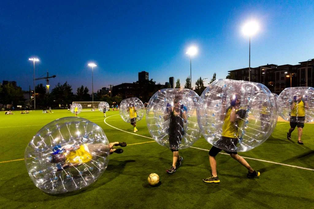 Players push downfield, often to collide, while encased in bouncy, blue orbs as part of Seattle's first "Bubble Futbol" - or soccer - tournament Sunday, September 7, 2014, at Cal Anderson Park in Capitol Hill in Seattle, Washington. The unlikely sport originated in Europe and is quickly sweeping the U.S., with a recent spotlight on The Tonight Show with Jimmy Fallon. The event was put on by Seattle-local nonprofit "The World is Fun" as a celebration of the organization's fifth anniversary. Photo: JORDAN STEAD, SEATTLEPI.COM