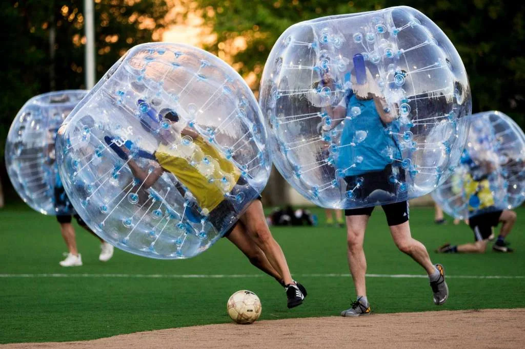 Players push downfield, often to collide, while encased in bouncy, blue orbs as part of Seattle's first "Bubble Futbol" - or soccer - tournament Sunday, September 7, 2014, at Cal Anderson Park in Capitol Hill in Seattle, Washington. The unlikely sport originated in Europe and is quickly sweeping the U.S., with a recent spotlight on The Tonight Show with Jimmy Fallon. The event was put on by Seattle-local nonprofit "The World is Fun" as a celebration of the organization's fifth anniversary. Photo: JORDAN STEAD, SEATTLEPI.COM