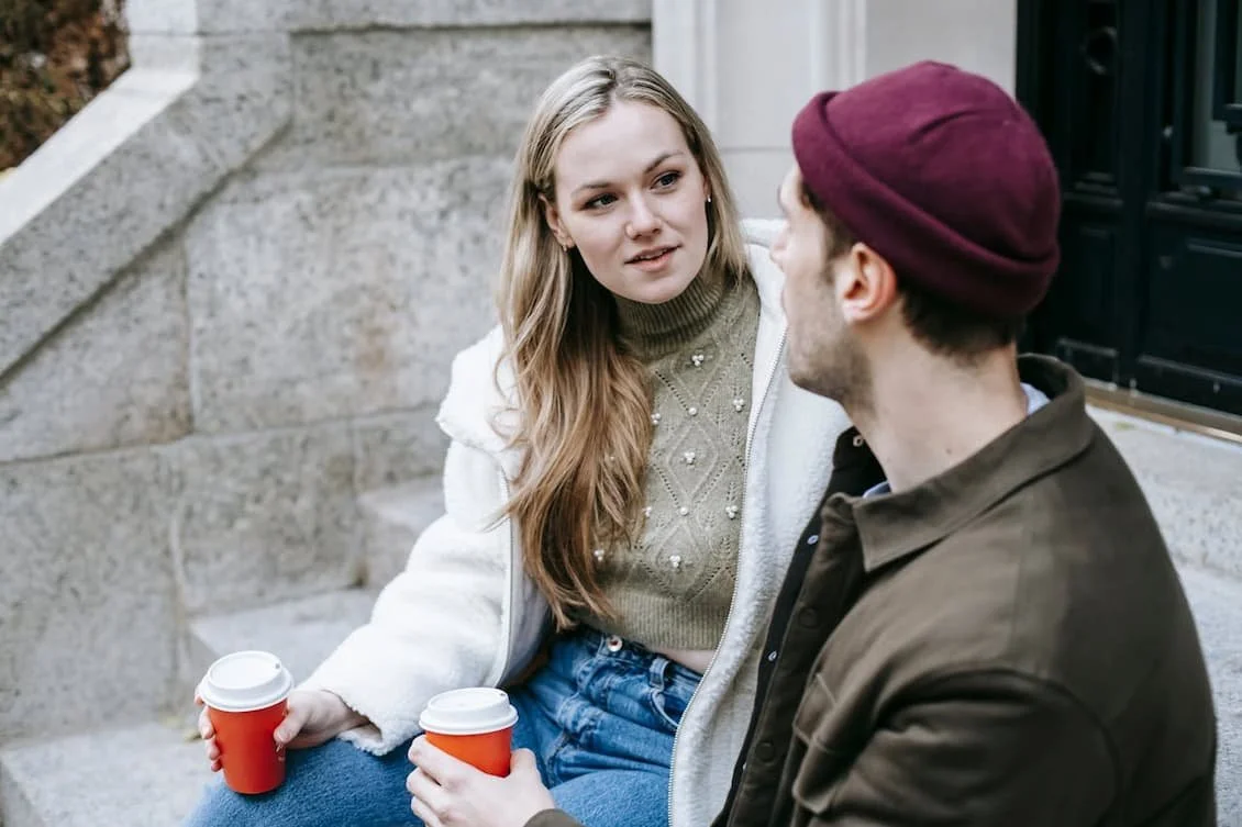couple-talking-and-drinking-beverages-on-stairs