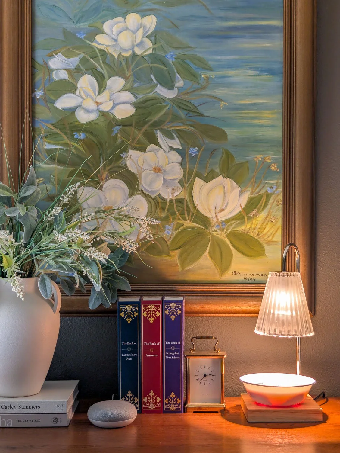 A close-up of a warm light from a candle warmer lamp heating a bowl of sliced apples and spices on a traditional wooden tabletop.