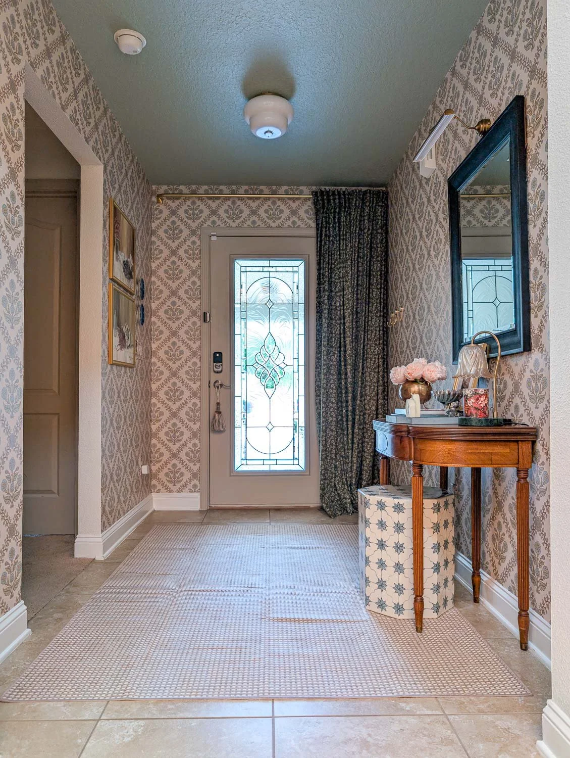 n a moody traditional entryway, the "Floral Legacy" patterned wallpaper by Love vs. Design creates a high-impact transformation of the once bland walls.