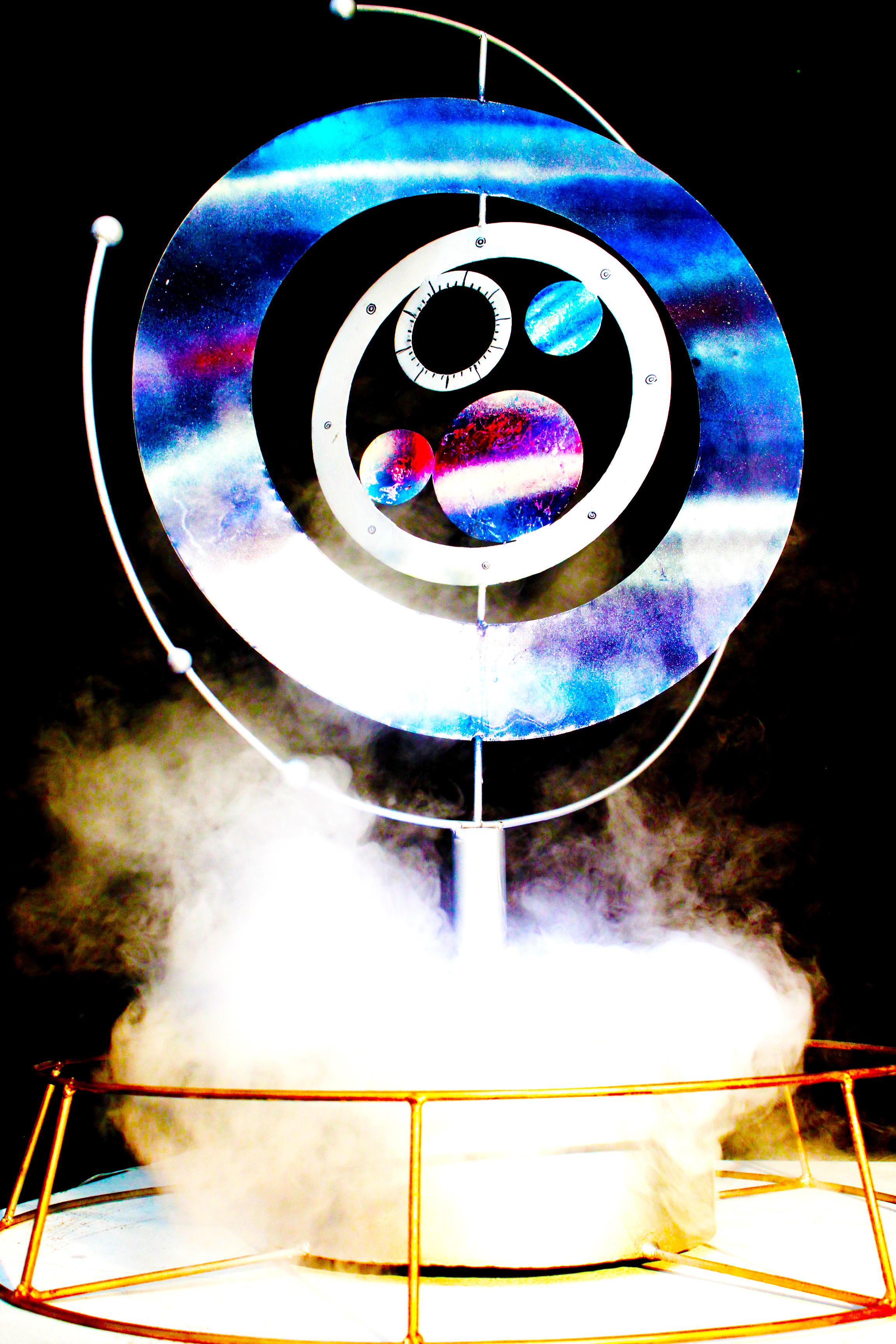 Metallic sculpture, spray paint, LED lights, and fog