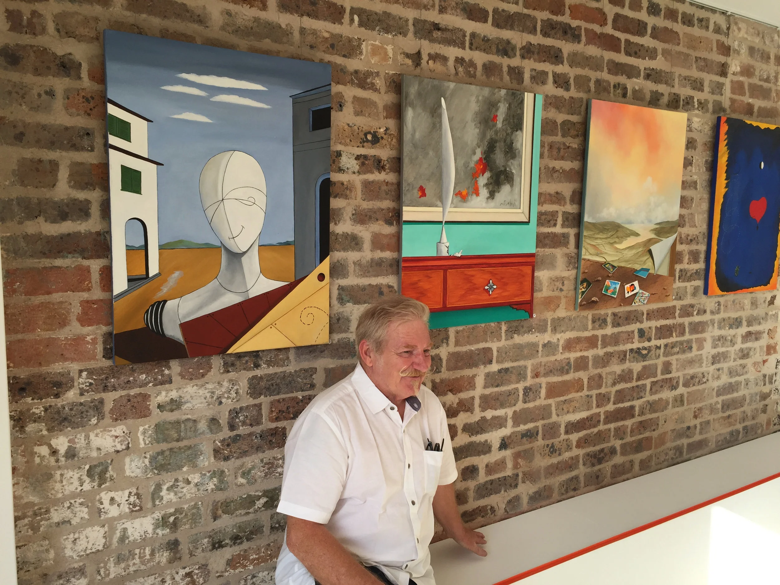 Ivor Cole under his painting "The Poet Smiles" at Disorder Gallery