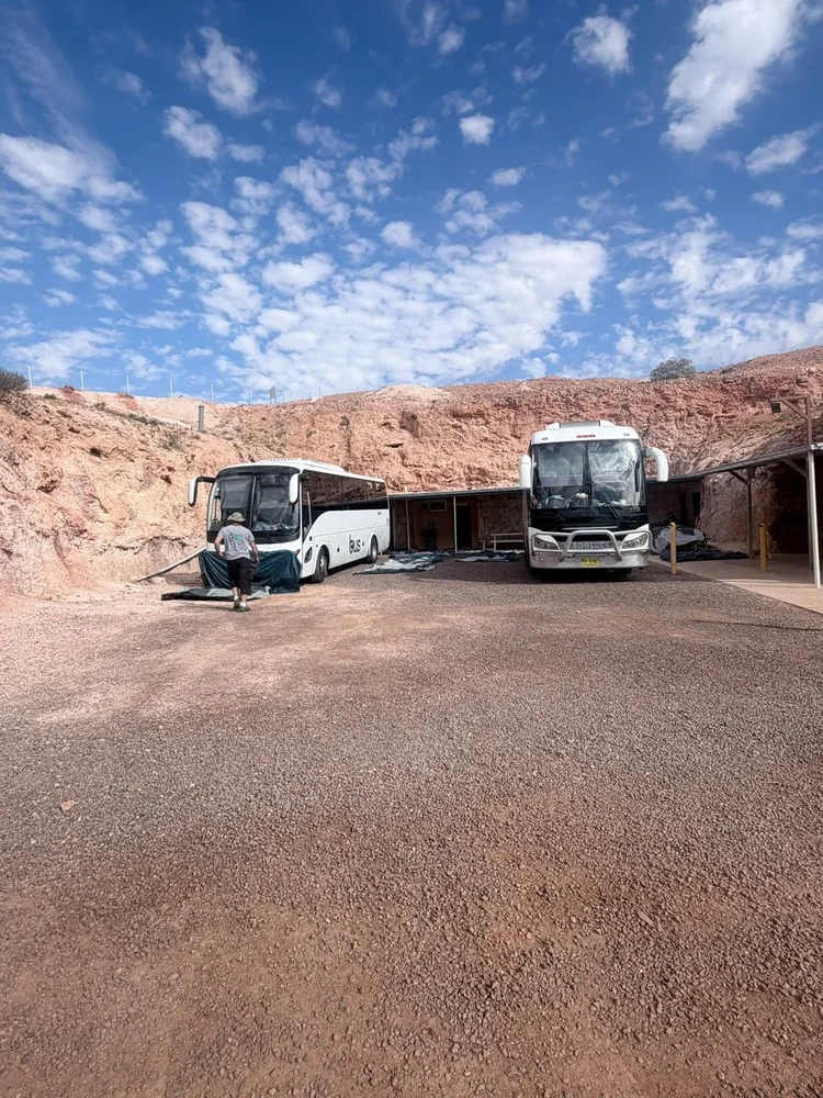 Two Urban Legends coaches at an outback rest stop on an interstate tour