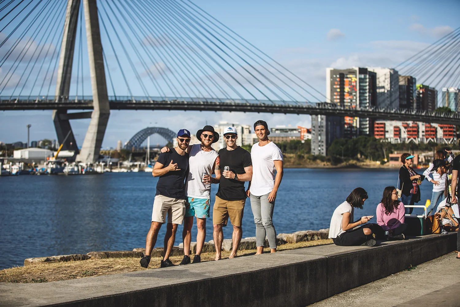 Friends on a private tour at Blackwattle Bay in Glebe, with the Anzac Bridge overhead and the Harbour Bridge in the distance