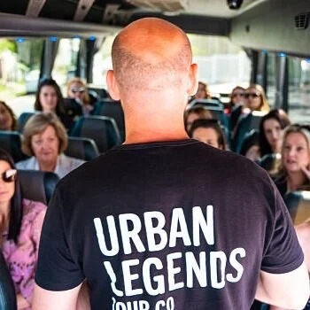 Jared from Urban Legends talking with a passenger beside the tour vehicle