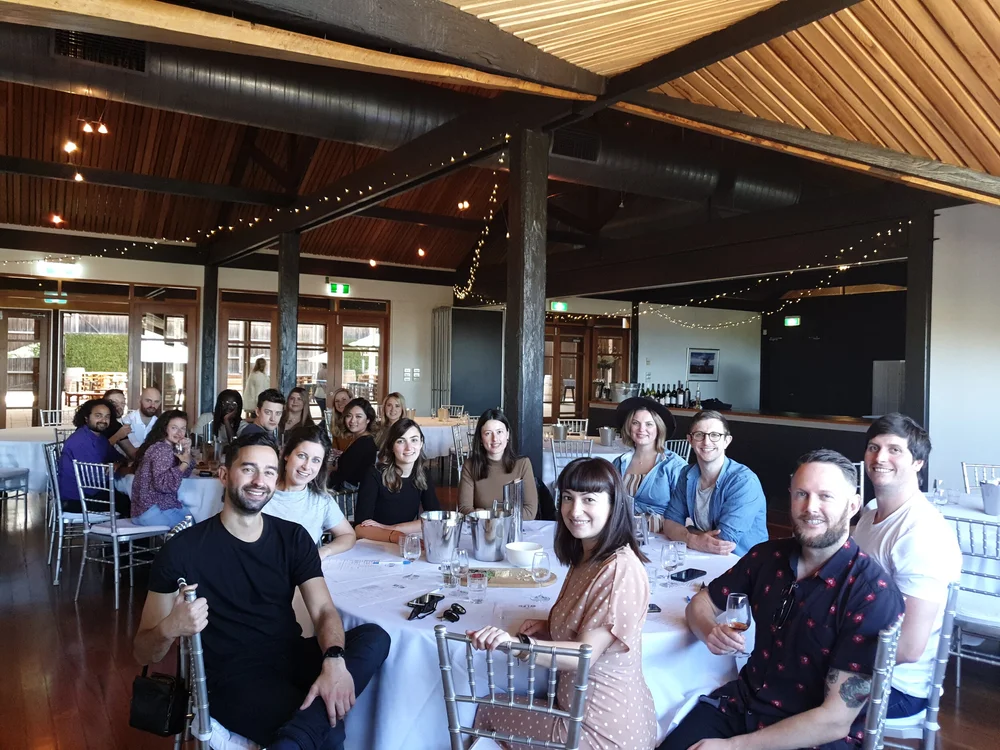 A smiling group seated at round tables during an event at a Hunter Valley venue