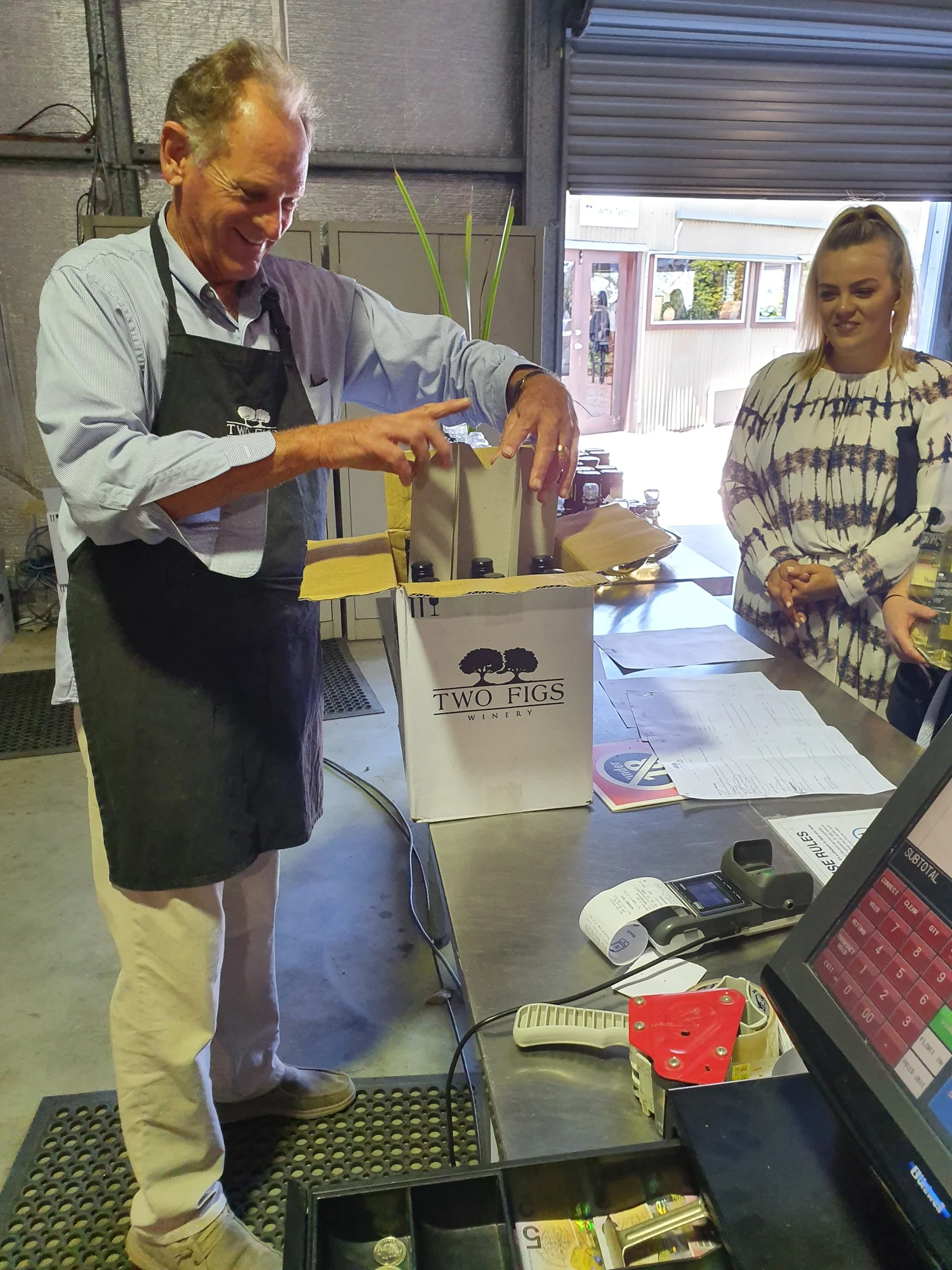 Guest buying a bottle of wine at a boutique cellar door to support local winemakers