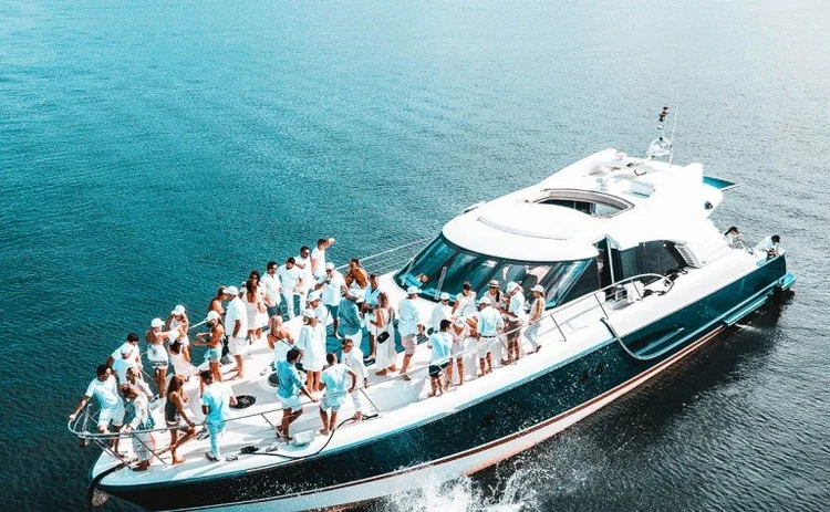 A private yacht full of guests dressed in white on Queensland water