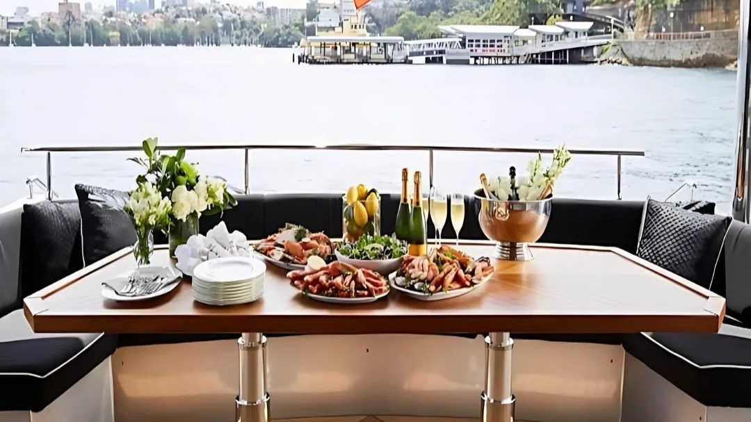 Catered grazing table and champagne set up on the aft deck of a Sydney Harbour yacht charter with the Opera House behind