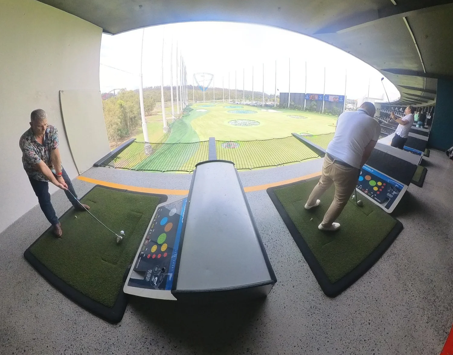 Work team taking a swing at Topgolf on a Brisbane team building day