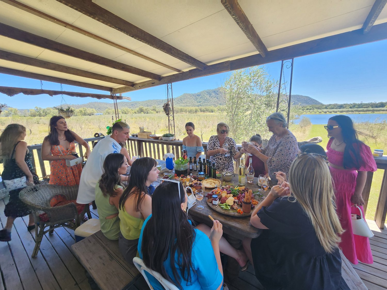 A group sharing a grazing table on a shaded verandah overlooking Hunter Valley wine country