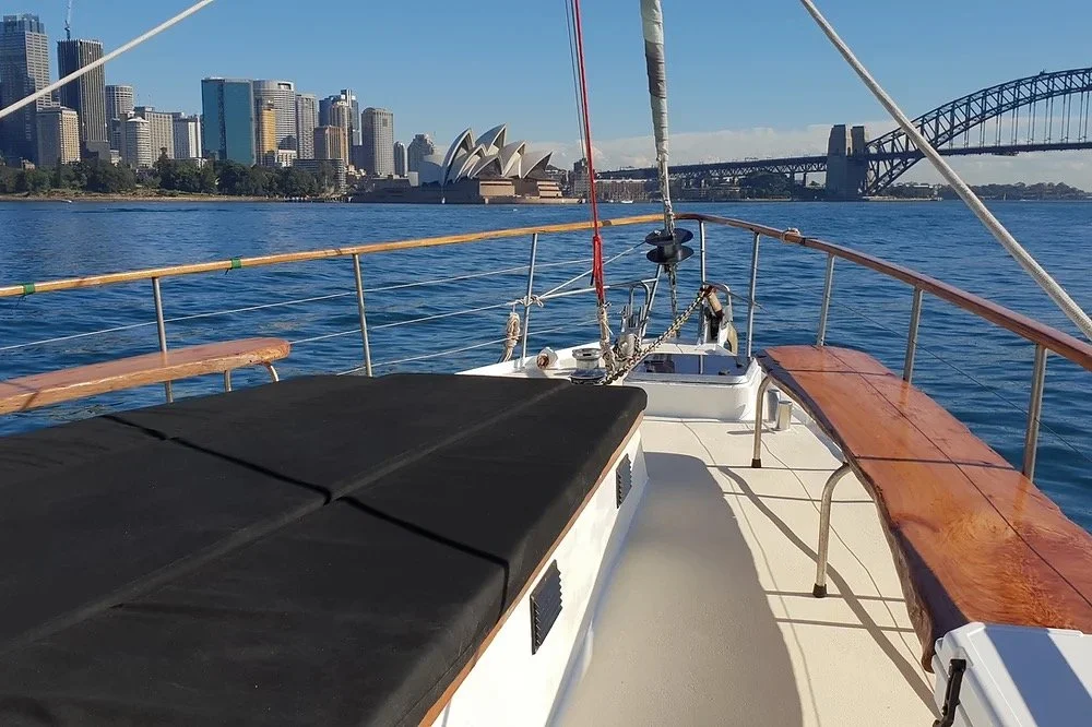 Group on a Sydney Harbour yacht charter foredeck with the Harbour Bridge behind, a relaxed alternative during Mardi Gras weekend