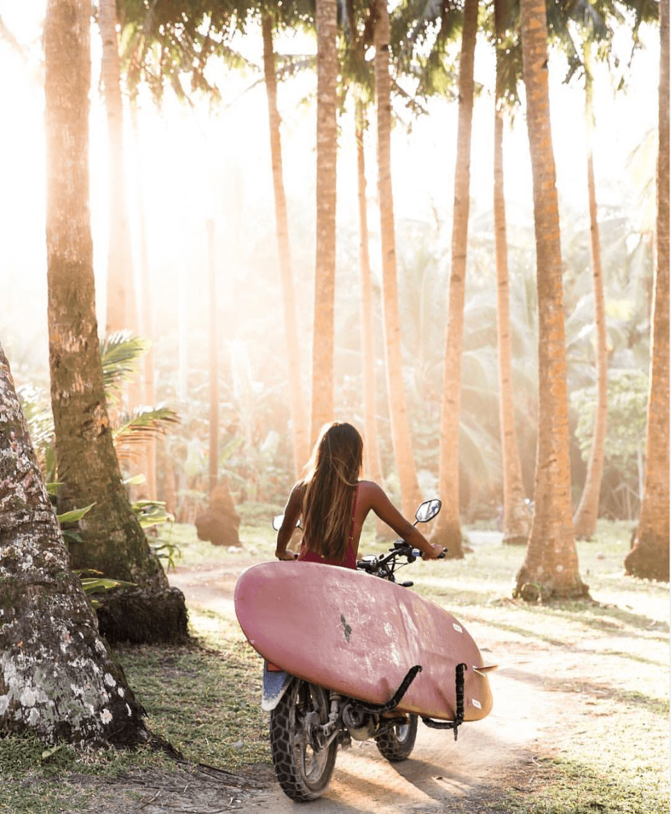 girl-on-bike-with-board-siargao-photo-min.png