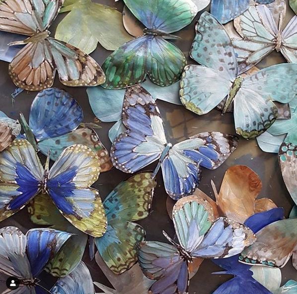 Detail photo of the butterflies being created with custom blended shimmer paint- replicating the true natural iridescence of their wings.