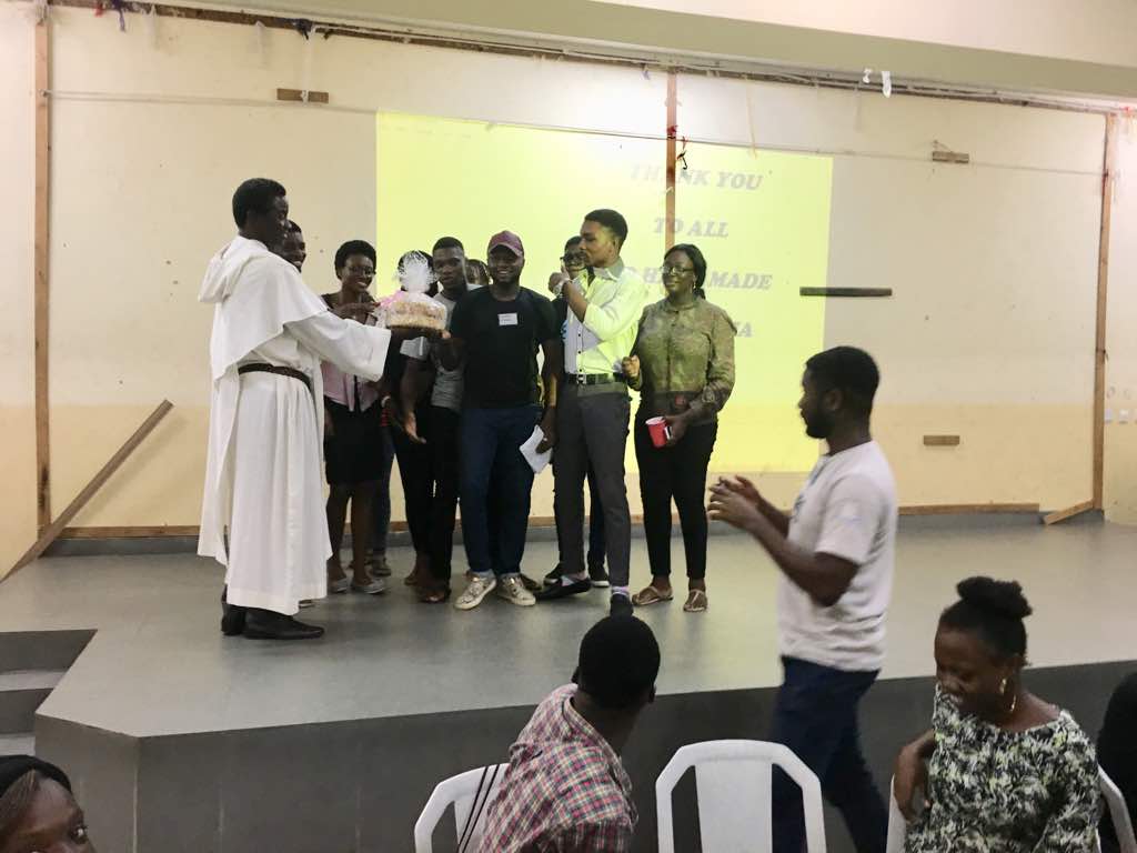 Fr Paul (OP) with some of the students posing with a special cake during Alpha Celebration Mass