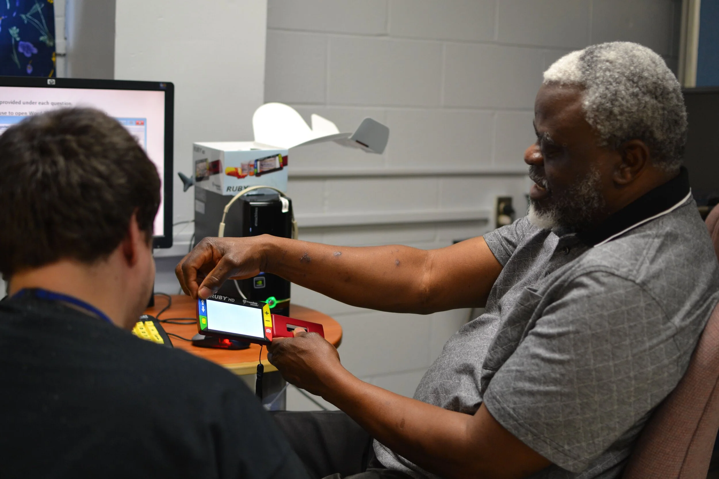 ati student teaching another client about a magnifier