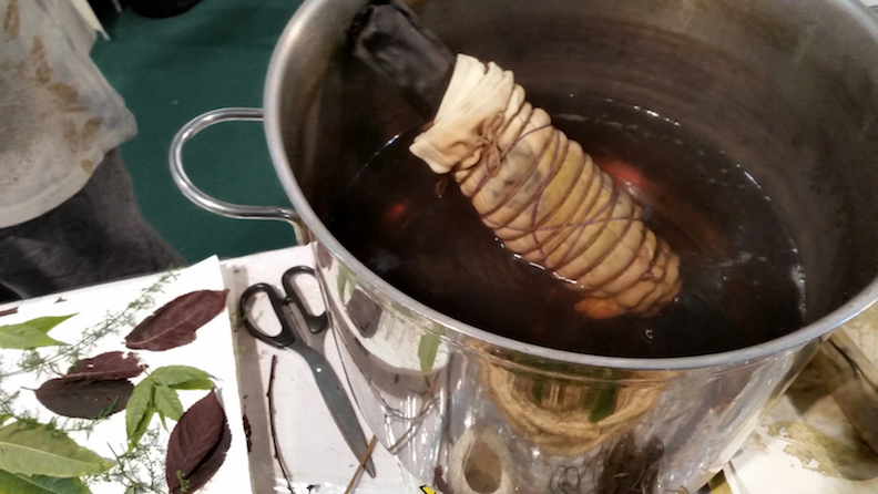The cloth must be tightly secured around a tube and boiled in water for one hour so the natural dyes in the leaves can be extracted.