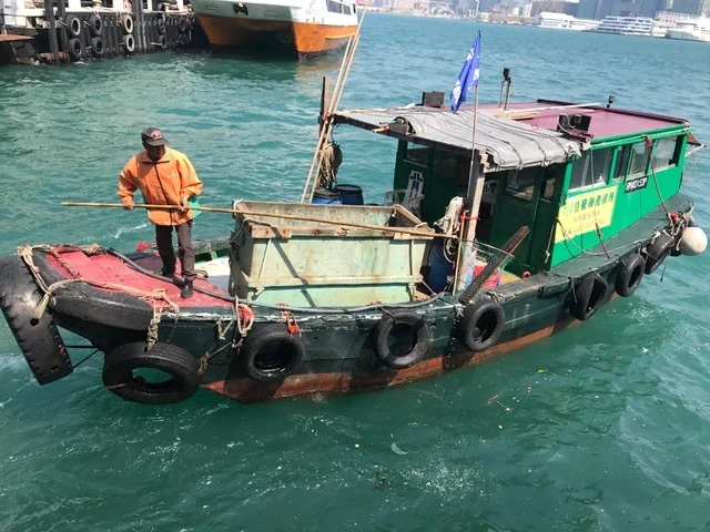 Picking up garbage on water in Hong Kong harbor. Never saw that in NYC.