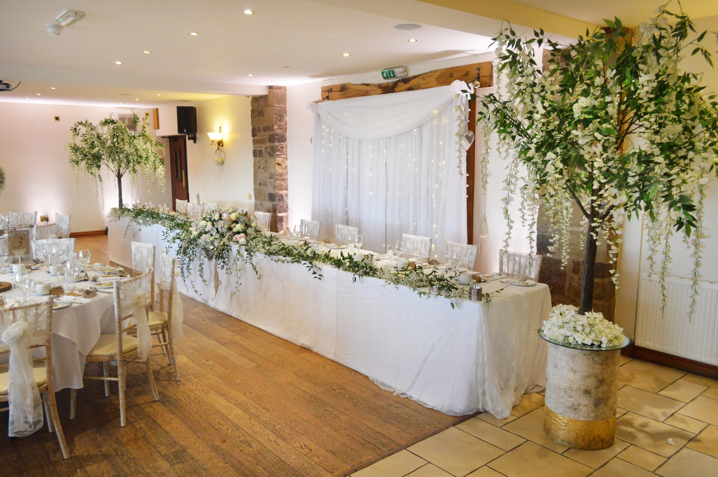 Wisteria trees next to the top table on logs