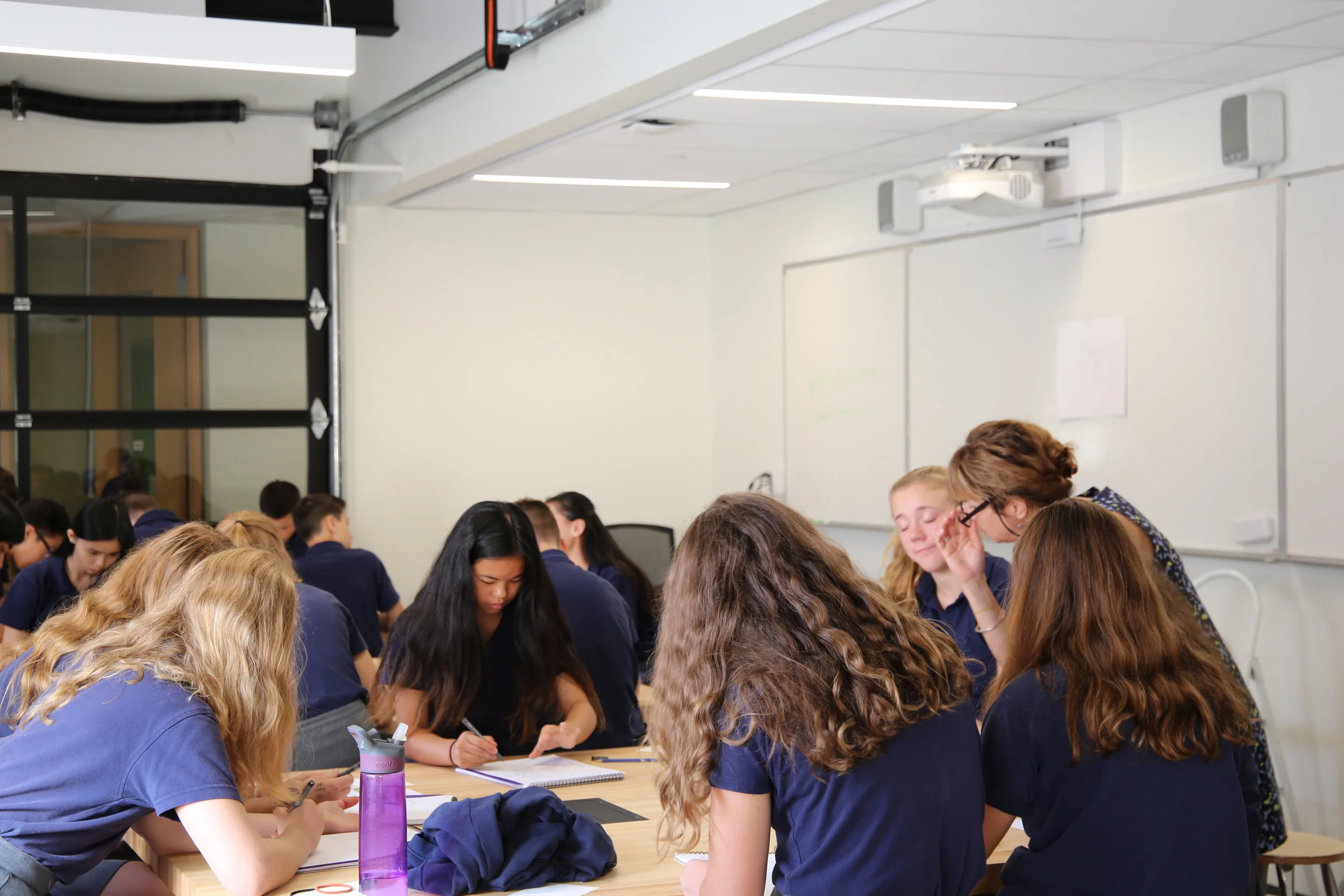 Students work on drawings with Ms. Balomenos, Senior School Art Teacher