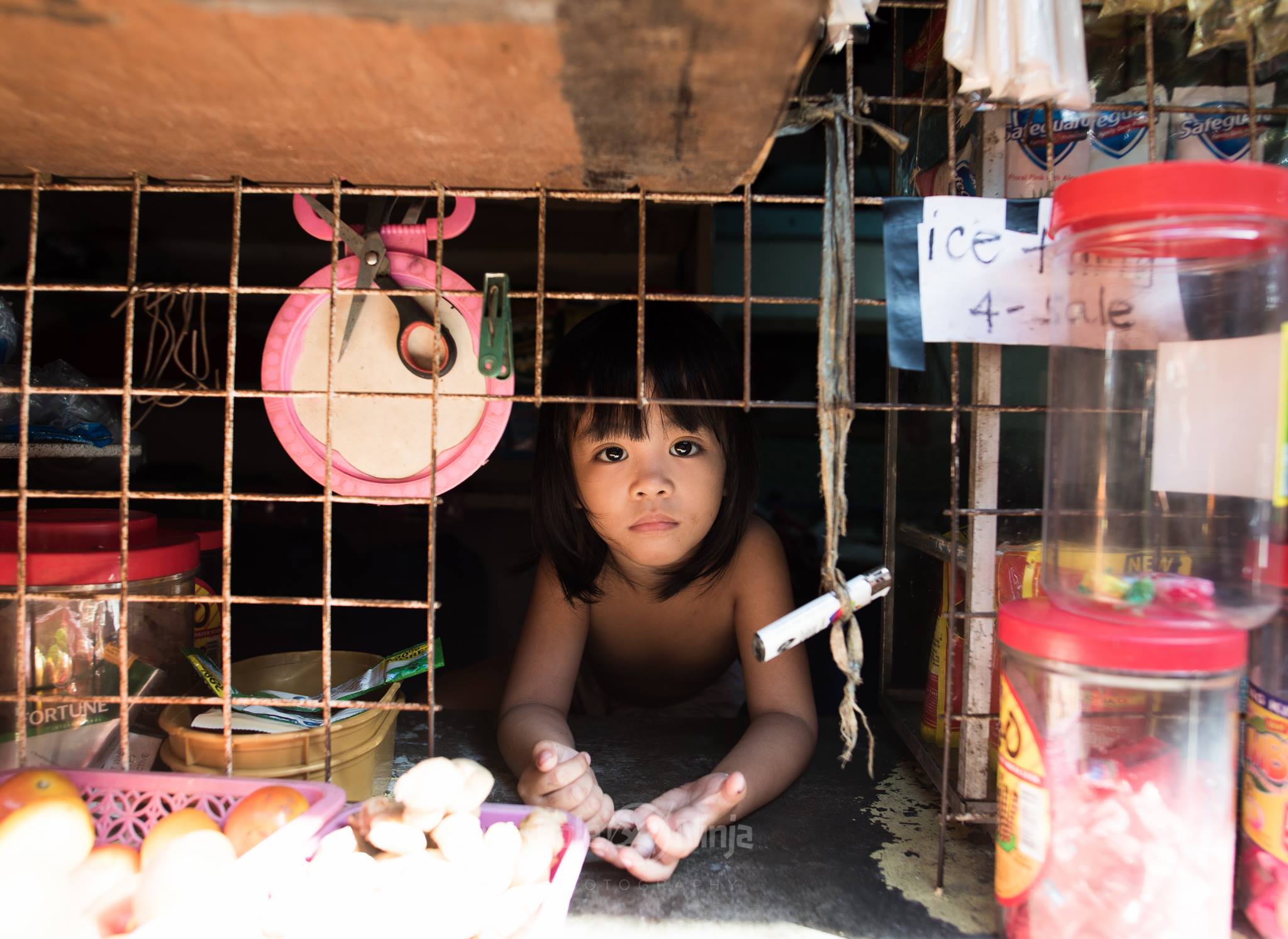  To me, this was the shot that made the entire journey worth it. This young girl, in the middle of the slums, peeked through the store window. I barely got the shot off before she was gone, like she was never there.  The stores are relatively few, an