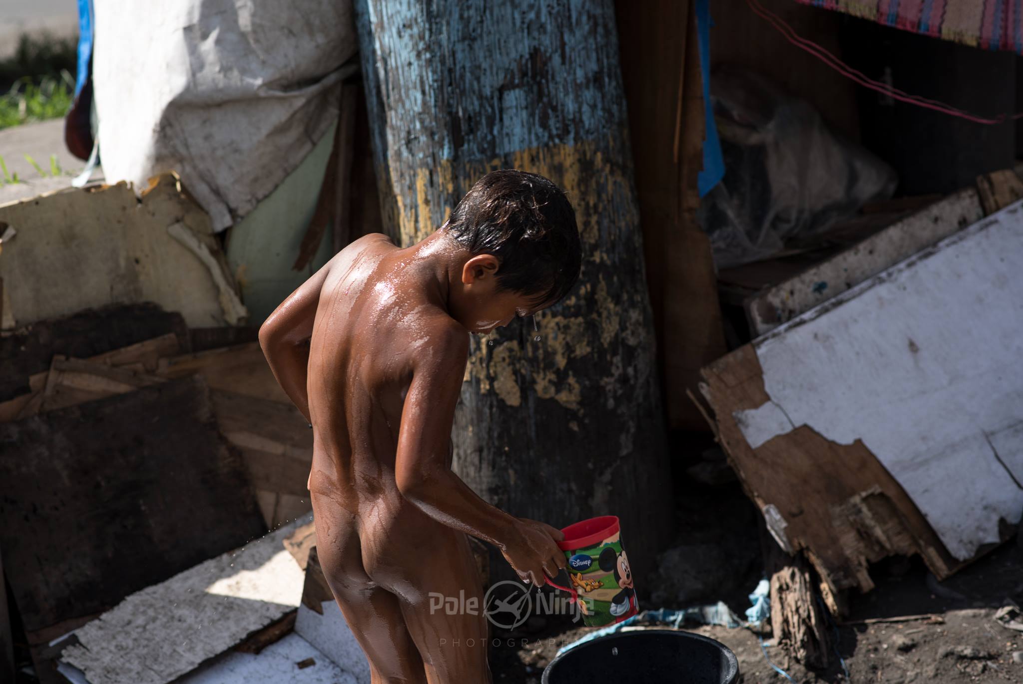  Since space is such an issue, bathing in public is quite common, using a cup of river water or still water. You can't see in these photos, but many families are living close by this shot out of concrete cylinders--sewage drain pieces, I think. 