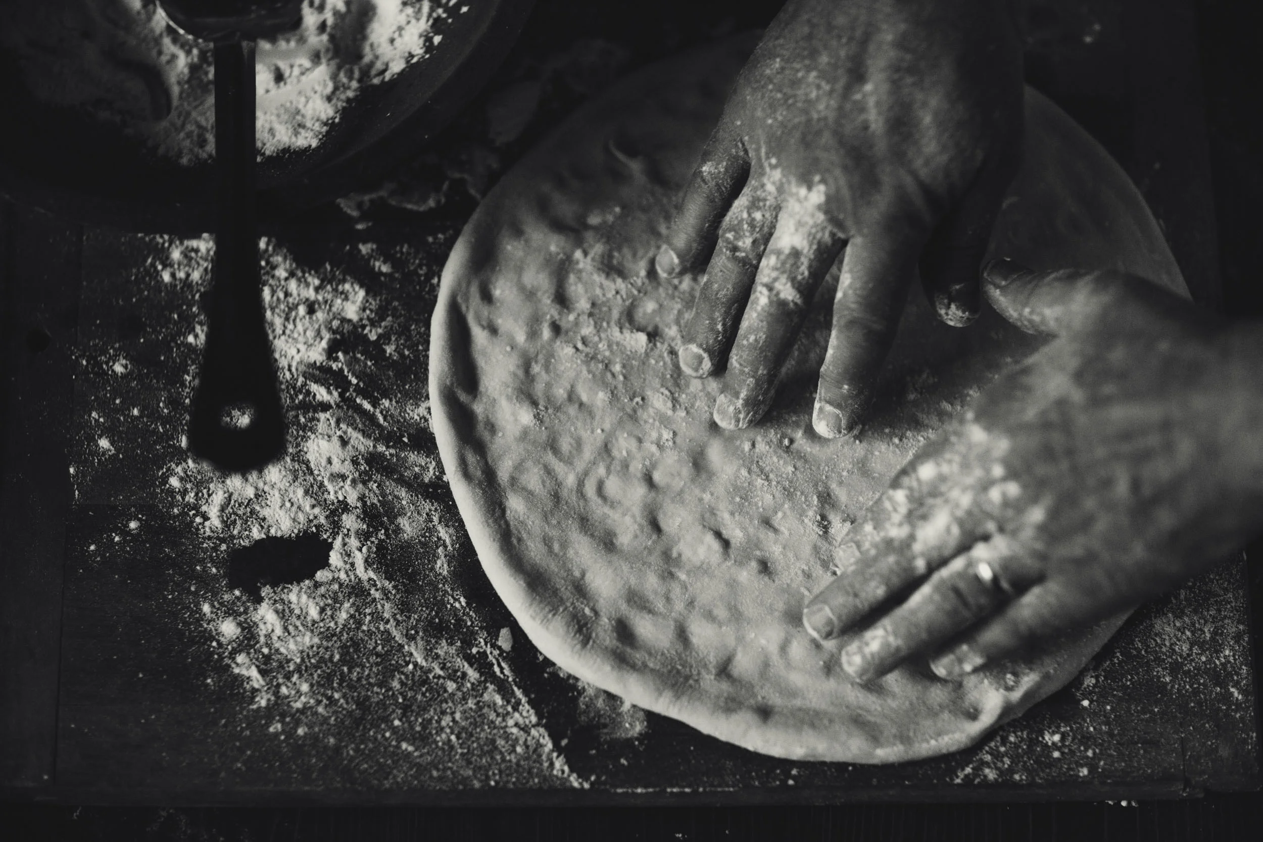Hand tossed pizza dough flour covered hands