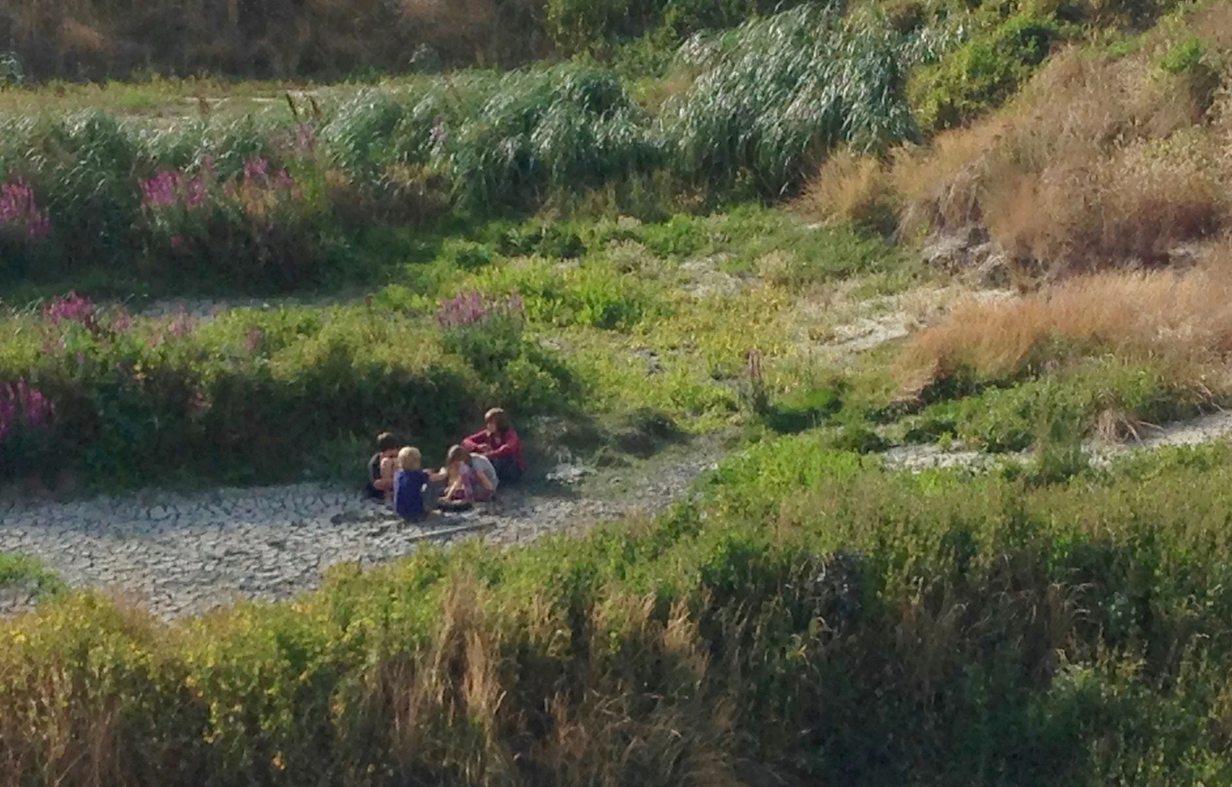 Boat kids enjoying their own world in a cool sandpit; Newport, OR.