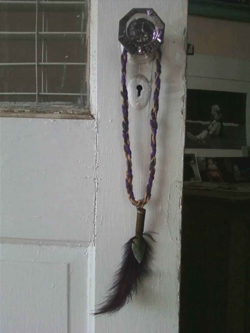 Medieval braid with bullet shell, arrowhead and feather.